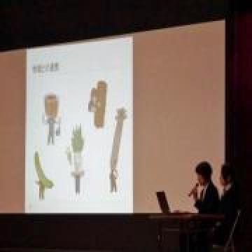 スクリーンを使い実践発表をしている山西栄養教諭と井山調理員の写真