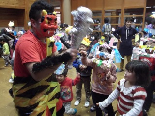 金棒を持った赤鬼が子ども達を襲おうとしている節分集会の写真