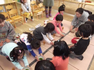 作法を習いながら、目の前に座っているお友達にお抹茶を出している年長組お抹茶教室の写真