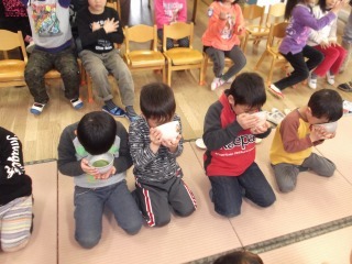 畳の上に横一列に並んで座っている男の子達が両手をお茶碗を持ってお抹茶を飲んでいる年長組第2回お抹茶教室の写真