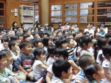 子どもたちが人形劇を鑑賞して笑っている様子の写真