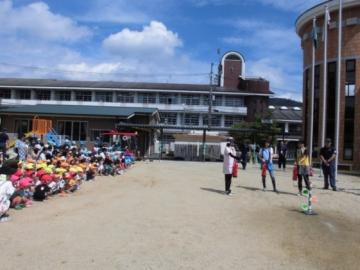 5名の保育士が水消火器訓練を子どもたちが見守っている様子の写真
