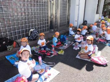 子どもたちがシートをひろげお弁当を食べている様子の写真