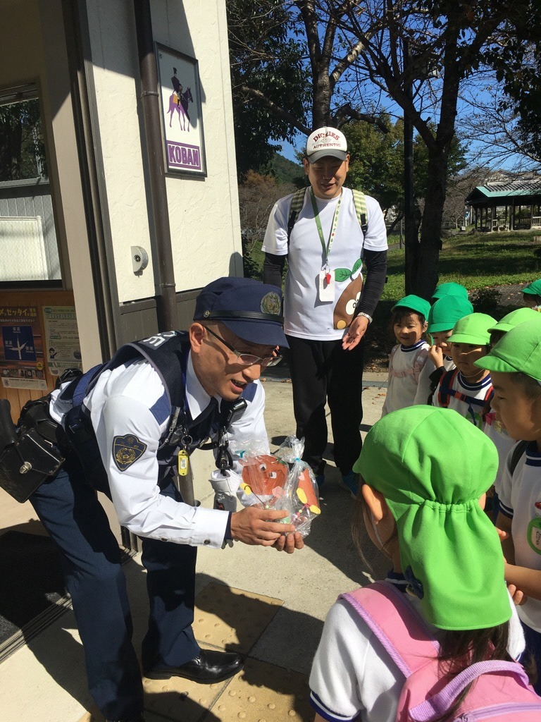 交番の警察官に勤労感謝のプレゼントを渡している様子の写真