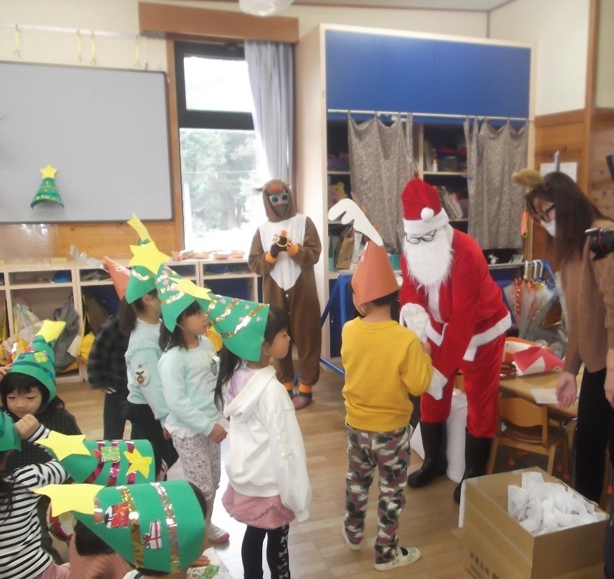 子ども達がサンタクロースからプレゼントを受け取っている様子の写真