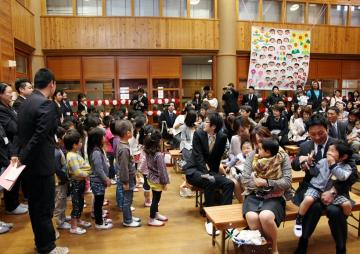 年長児が新入児に対してお祝いの言葉と歌を披露している写真