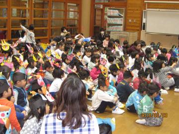 子どもたちが鬼のお面をかぶって話を聞いている写真