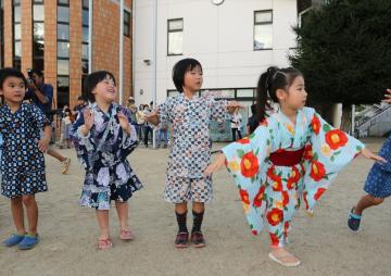 浴衣や甚兵衛を着た子どもたちが盆踊りをしている写真