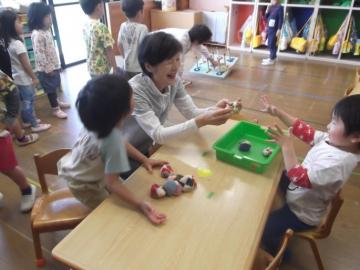子どもたちが老人クラブの方と一緒にお手玉などの昔遊びをしている写真