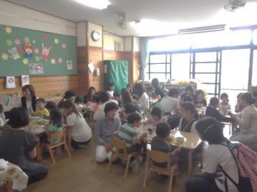 給食を食べている子どもたちと参観をしている保護者の方の写真