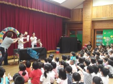 保育士が子どもたちの前で出し物をしている写真