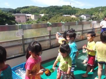 子どもたちが水鉄砲で的当てなどの水遊びをしている写真