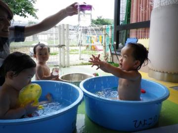 子どもたちがペットボトルシャワーをかけてもらっている様子の写真