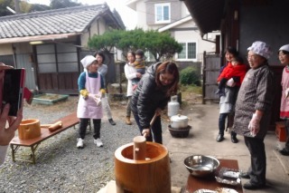 ママが杵を持っておもちをついている写真