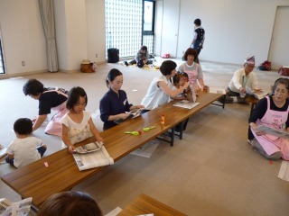 新聞紙でエコバックを作っている参加者の写真