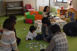 子育てカルタで親子とおばあちゃんが遊んでいる写真