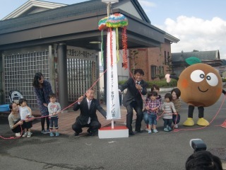 町長、子供たち、関係者がくす玉を割っている写真