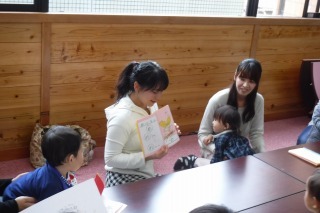 出来上がった絵本を参加者の皆さんに見せている女性の写真