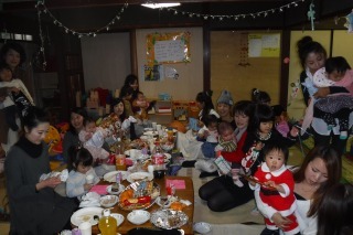 テーブルの上に食事が並びその前に親子が座っている写真