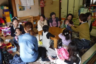 子供とママたちと年配の女性たちが一緒に遊んでいる写真