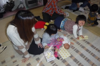 参加者の親子が包装紙を丸めて豆を作っている写真