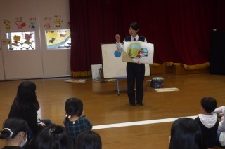 警察署の職員が紙芝居で、交通ルールについて話しをしている写真