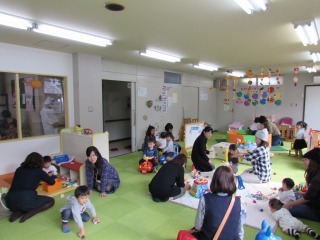 沢山のおもちゃがあるプレイルームであそんでいる親子の写真