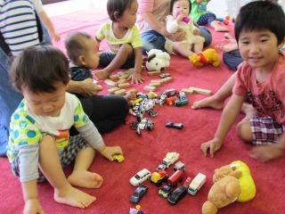 子ども達がミニカーや積み木などで遊んでいる写真