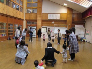 手をつないで輪になっている親子の写真