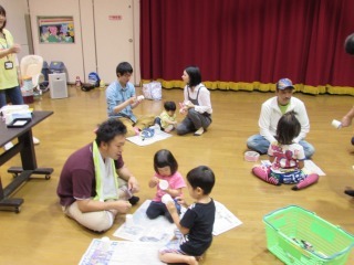 パパと一緒に紙コップのロケットを作っている子供たちの写真