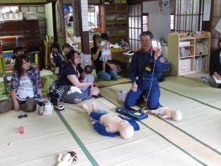 消防士が参加者にAEDの使い方を教えている写真