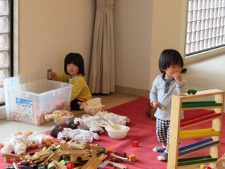 2人の子どもが木のおもちゃであそんでいる写真