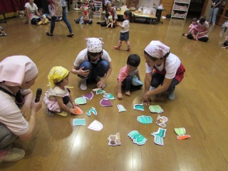 子ども達がママと一緒に野菜の絵合わせゲームを楽しんでいる写真