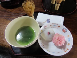 お茶とお皿に入った干菓子と、さくら上用饅頭の写真