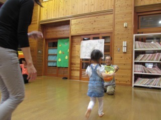 子どもたちが指定された色のカラーボールをカゴで運ぶミニ運動会の写真