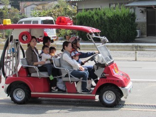 ミニ消防車に試乗している親子の写真