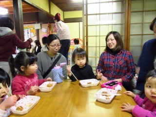 トレイに入ったおもちを食べている子供達の写真