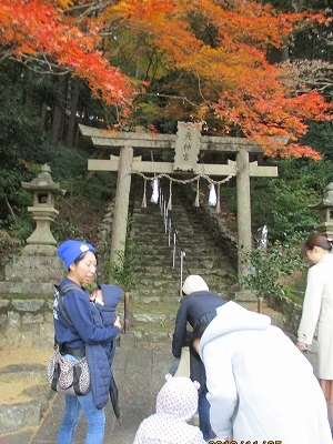 神社の前で一礼している親子さんたちの様子の写真