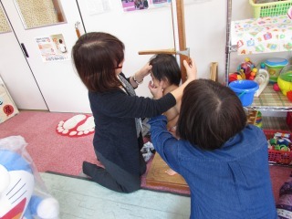 お母さんと一緒に子どもの身長を測っている写真