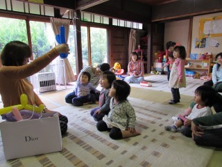 子ども達が座ってアートバルーンを見ている写真