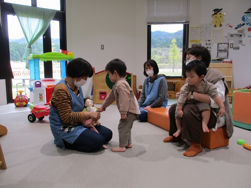人形と遊んでいる男の子の写真