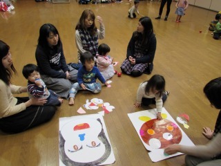 参加者の親子が、手作りの「茶ッピー」や「おたふくさん」で、福笑いをしている写真