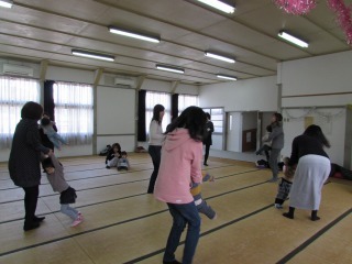 子どもとママが向きあい、子どもを持ち上げて大きく揺らす遊園地ごっこをしている写真