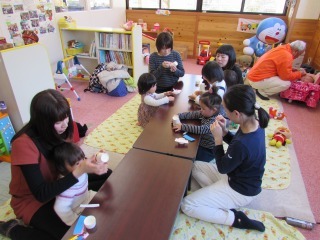 お雛様糸電話を作っている親子の写真