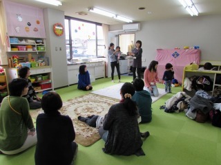 前方に女性が立って自己紹介をしている写真