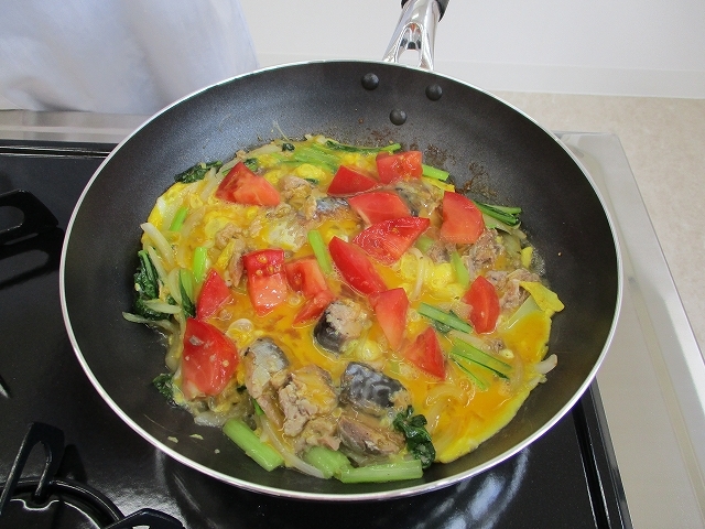 麺ゆつ、トマトを加え、卵でとじている写真
