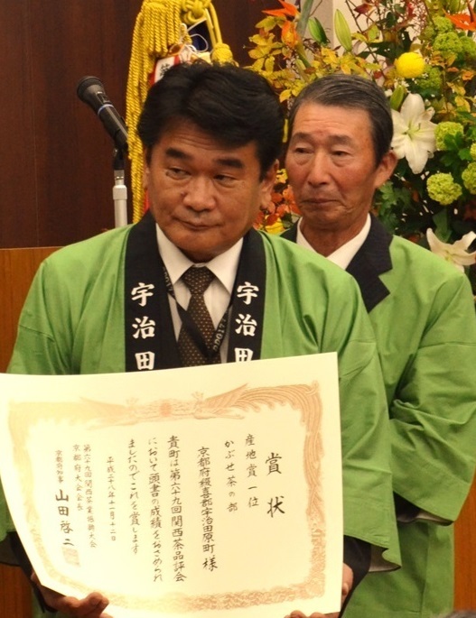賞状を持っている法被姿の西谷信夫町長の写真