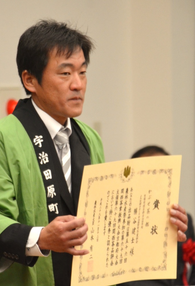 両手で賞状を持っている法被姿の勝谷さんの写真