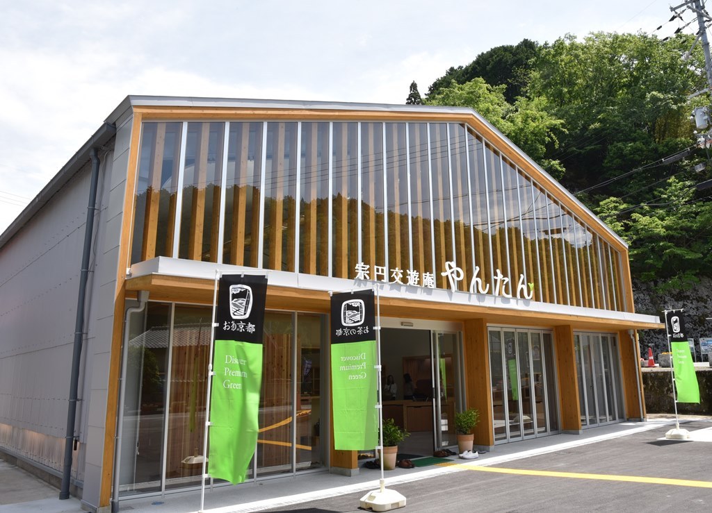 たくさんの木柱とガラス張りの宗円交遊庵やんたんの外観の写真