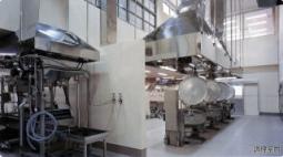 大きな釜が並んでおり、大型の換気扇のような機械が設置されている田原町立学校給食共同調理場の写真